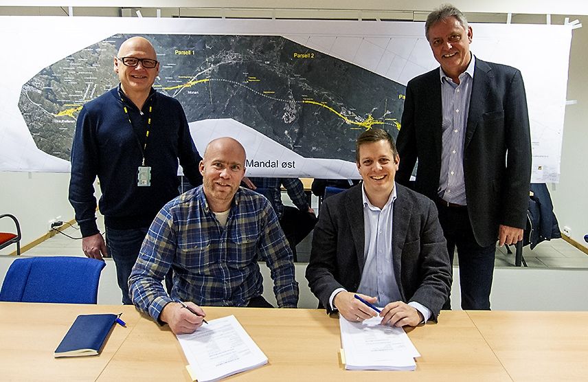 fire menn ser smilende inn i kamera etter signert kontrakt