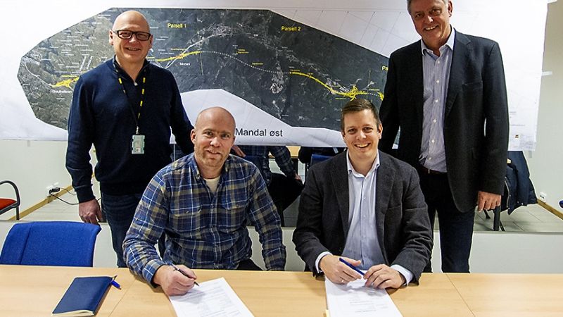 fire menn ser smilende inn i kamera etter signert kontrakt