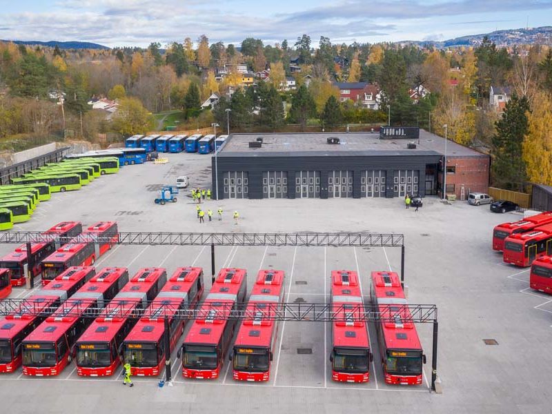 oversiktsbilde bussanlegg med parkerte busser og verkstedbygg i bakgrunn