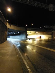inngangen til en tunnel tatt i mørket med veilys som lyskilde